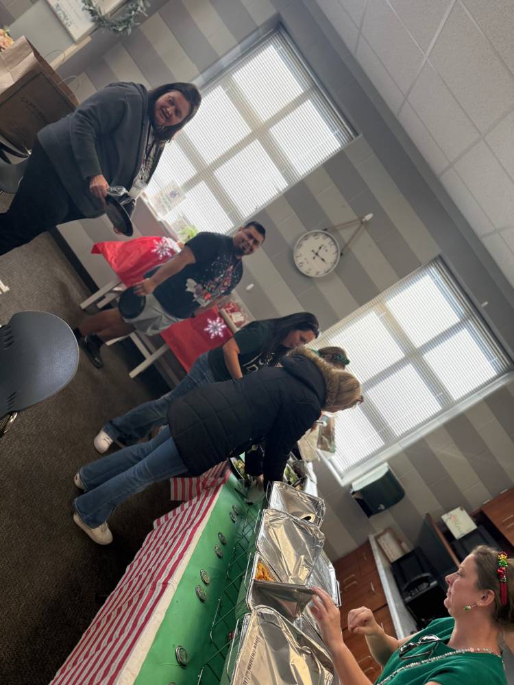 Table set with food and balloons at a community event in an elementary school.