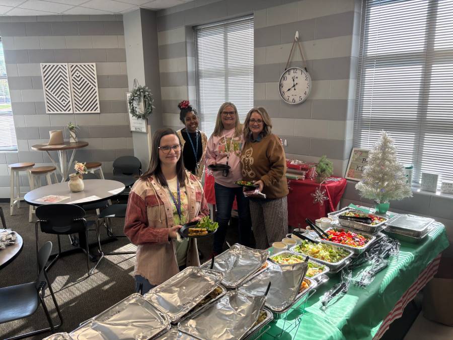 Guests enjoying food and activities during a community gathering at a school library.